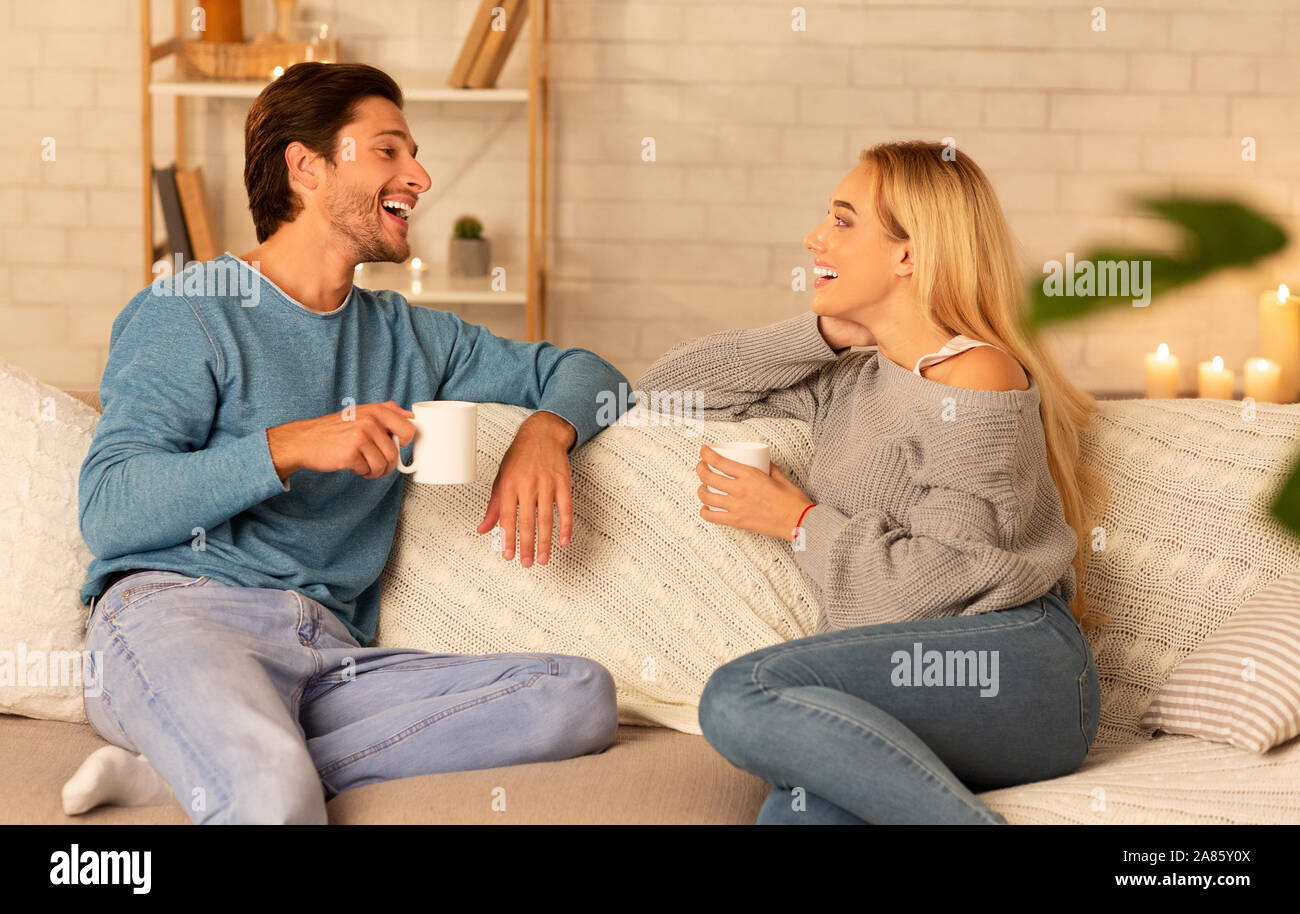 Paar beim Gespräch mit Kaffee sitzen auf der Couch zu Hause Stockfoto