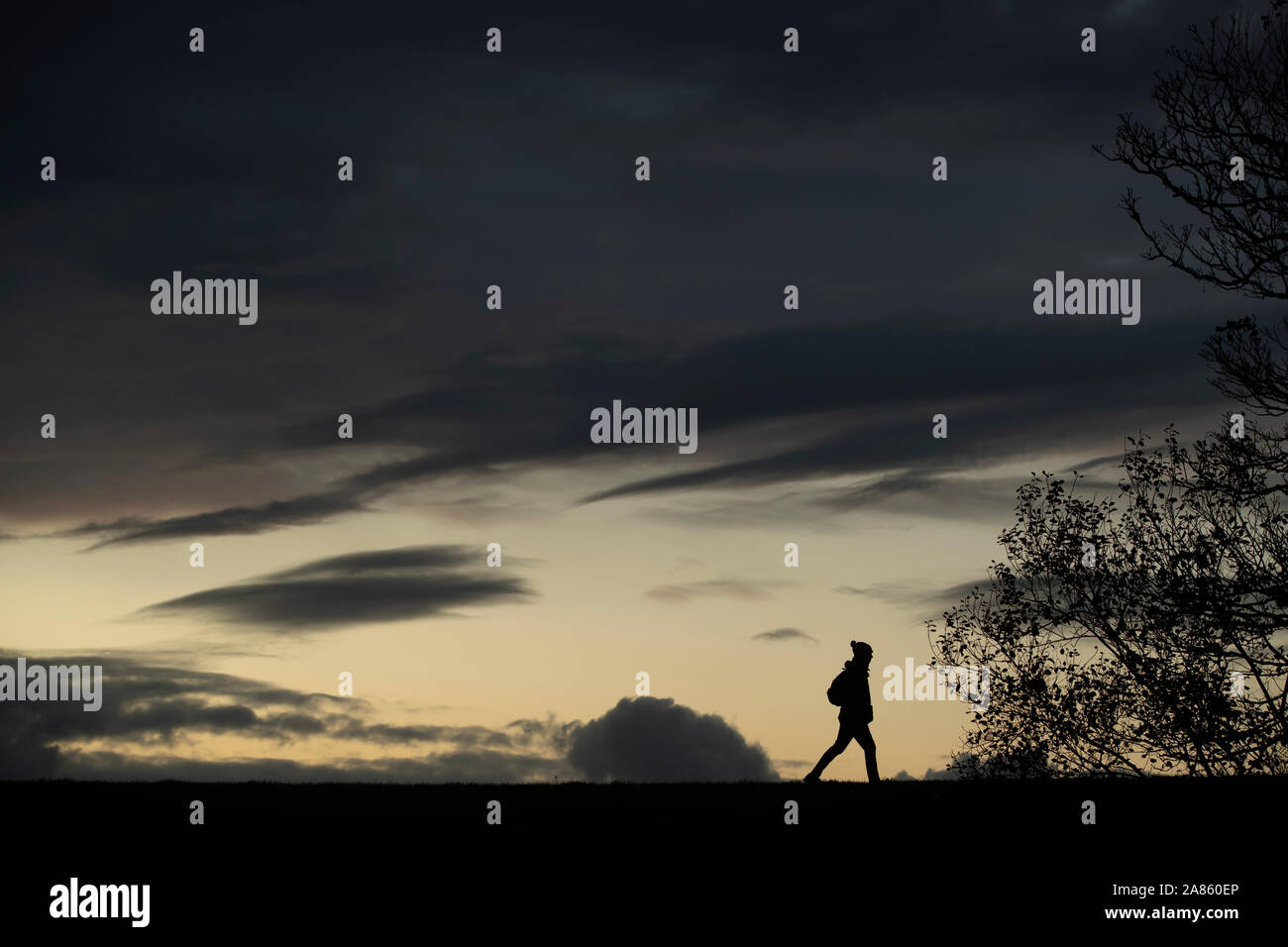 Ein Mann Spaziergänge bei Sonnenuntergang in Workington in Cumbria, wo heute Brexit Parteichef, Nigel Farage, adressiert Unterstützer an der Washington Central Hotel in einem Versuch, 'Workington Mann" zu gewinnen. Stockfoto