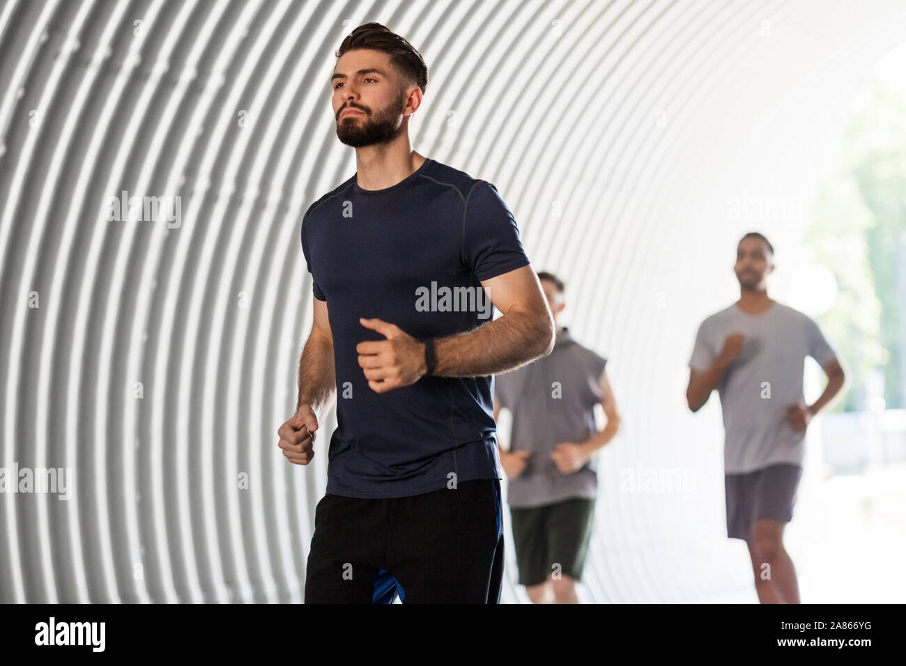 Junge Männer oder männliche Freunde laufen im Freien Stockfoto