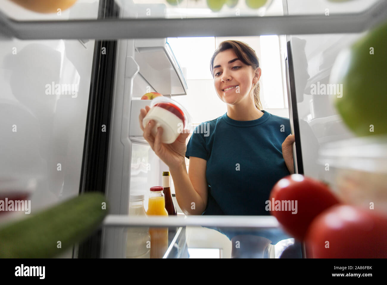 Glückliche Frau das Essen aus dem Kühlschrank zu Hause Stockfoto