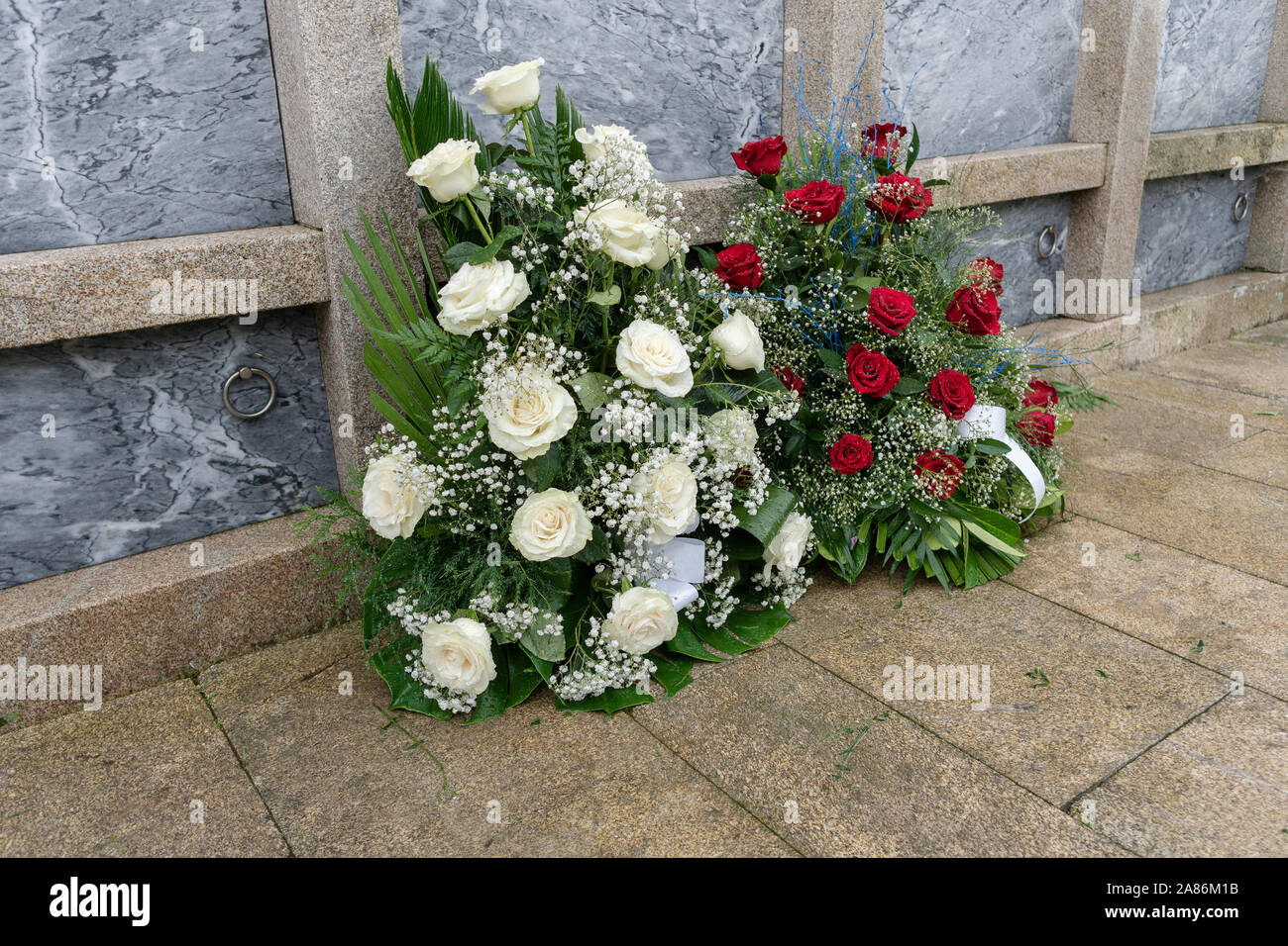 Blumenstrauß aus bunten Blumen während christliche Allerheiligen Veranstaltung im Grab auf dem Friedhof liegen. Tod Konzept Stockfotografie