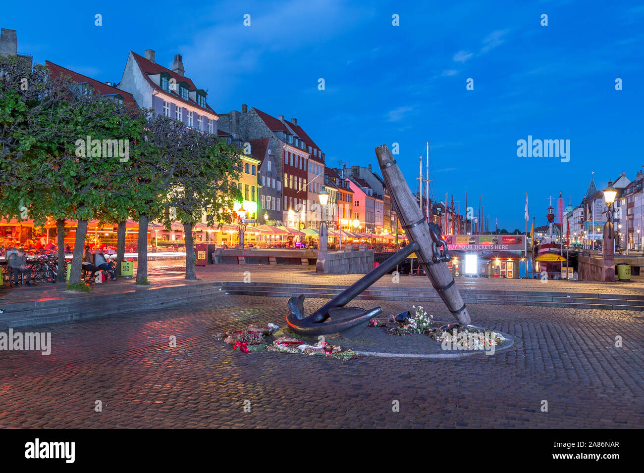 Kopenhagen, Dänemark - 22. MAI 2017: Das Mahnmal Anker (Mindeankeret) am Nyhavn in der Nacht. Gebäude, Restaurants und die Leute können gesehen werden. Stockfoto