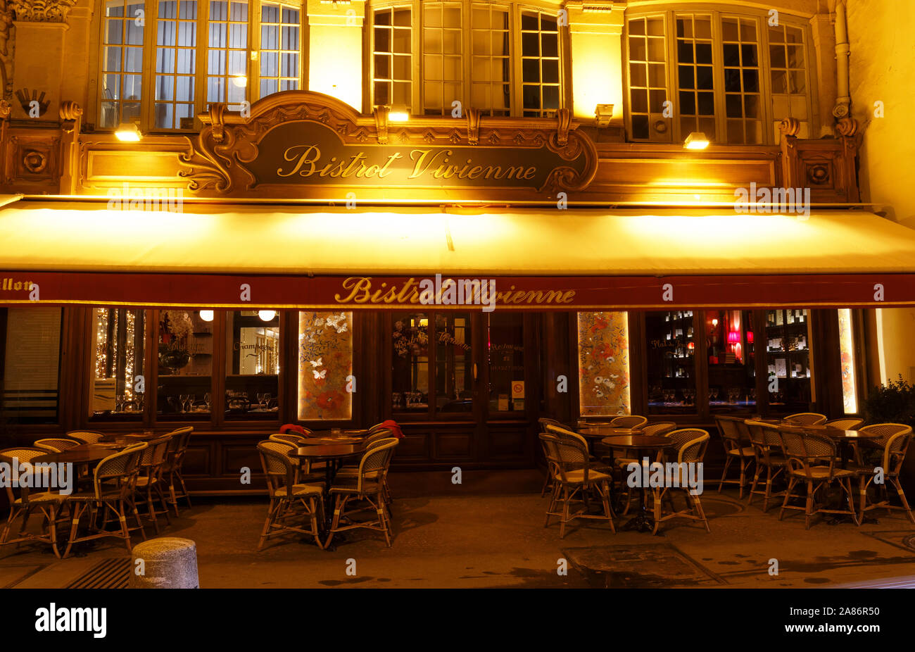 Bistro Vivienne im Herzen von Paris. Traditionelle Einrichtung, Terrasse mit grünem Dach, Tischen und Stühlen. Historische Gebäude Stockfoto