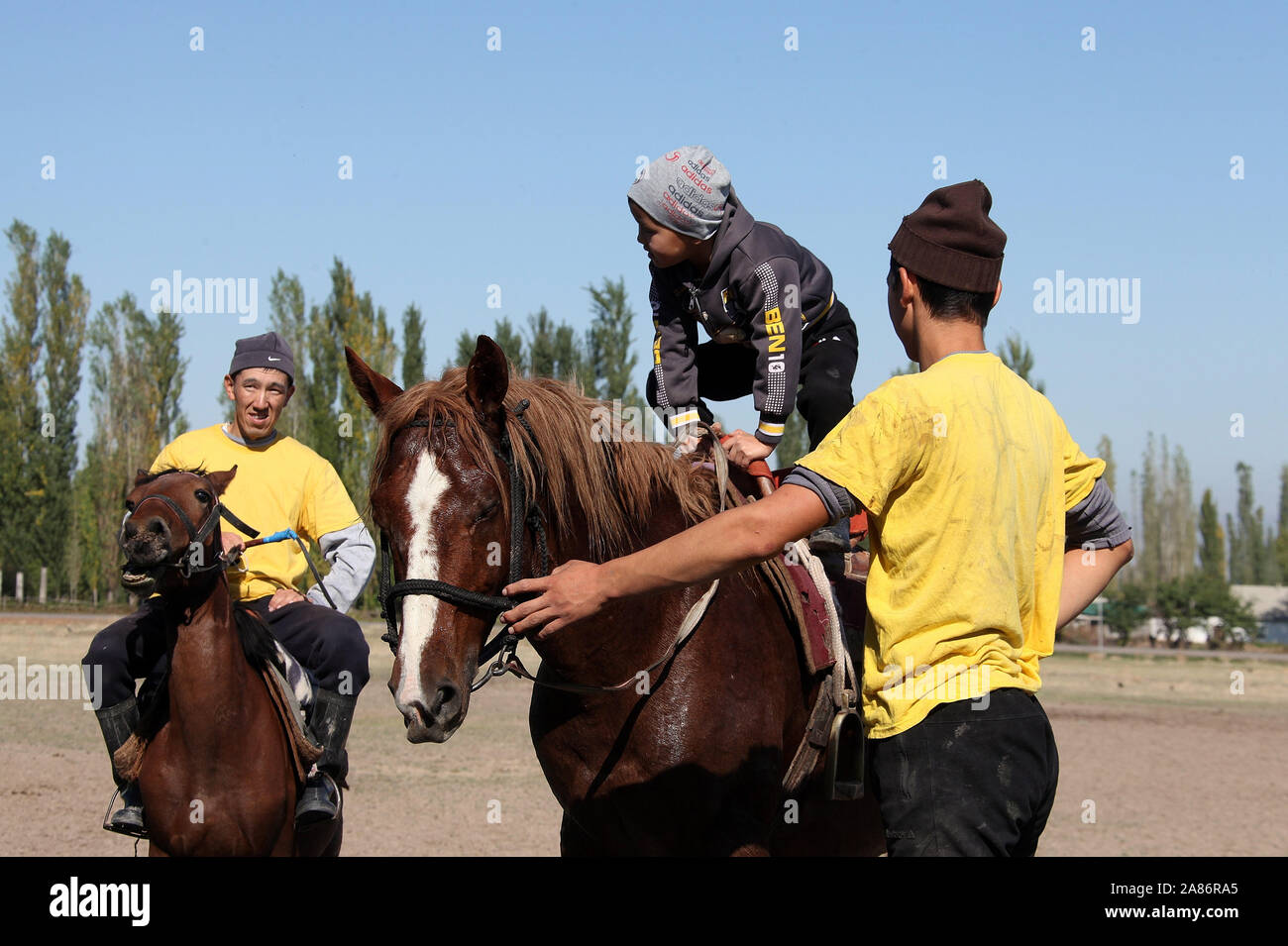 Buzkashi Sportler mit einem jungen Boy in Kirgisistan Stockfoto