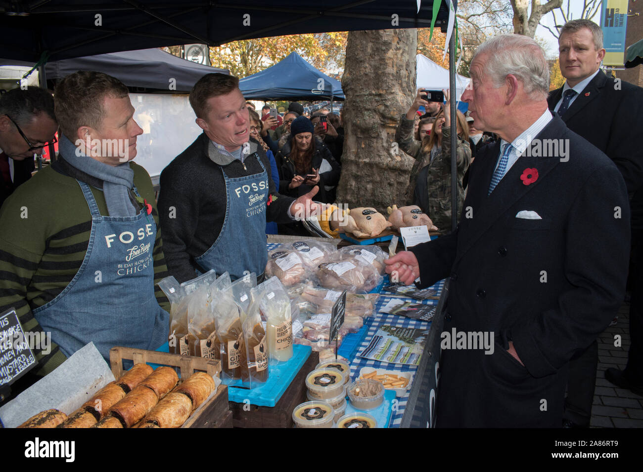 Prinz Charles an der Swiss Cottage Farmers Market, Konferenz Inhaber abgewürgt. Nick Ball und Jakob Sykes, die freie Strecke Huhn Landwirte von Fosse Mill Farm, North Kilworth, Leicestershire. Das ist der 20. Jahrestag der London Farmers Market. Prinz Charles und die Herzogin von Cornwall zu Besuch. 2019 das Ereignis zu gedenken. 2010 s HOMER SYKES Stockfoto