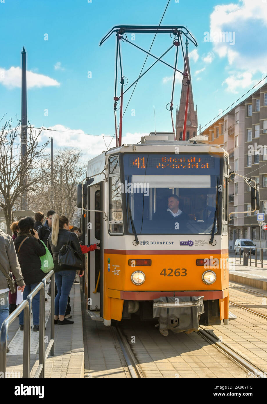 BUDAPEST, Ungarn - März 2019: Leute, die auf eine elektrische Straßenbahn an einer Haltestelle in Budapest City Center Stockfoto