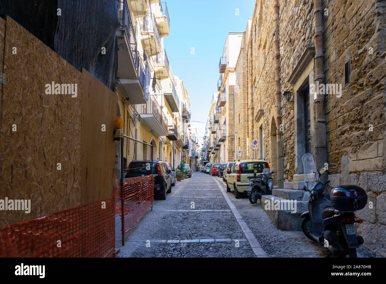 Einer der vielen bunten Seitenstraßen in Celafú, Sizilien, Italien, dieses Wohngebiet mit Kleidung lüften auf Balkonen. Stockfoto