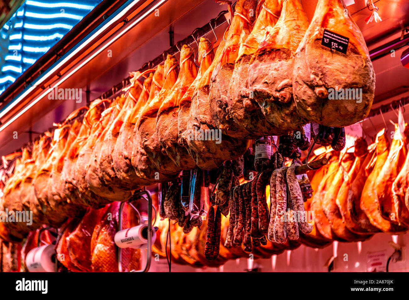 Ausgehärtete iberischen Schinken hängen über dem Metzger Abschaltdruck am Mercado Les Halles in Biarritz, Frankreich Stockfoto