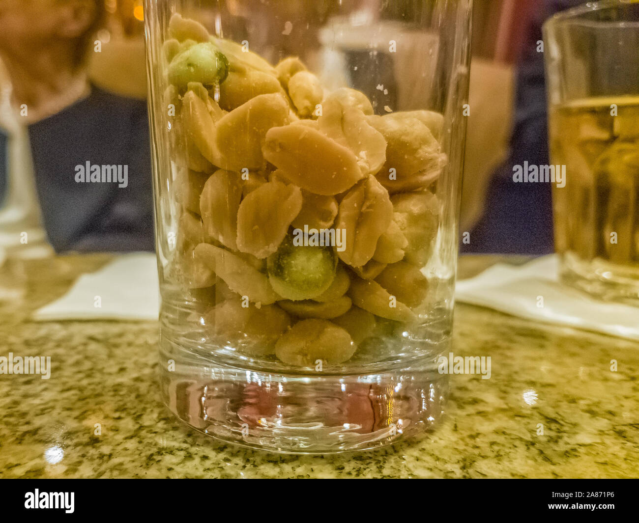 Glas voll Erdnüsse auf einem Tisch Stockfoto