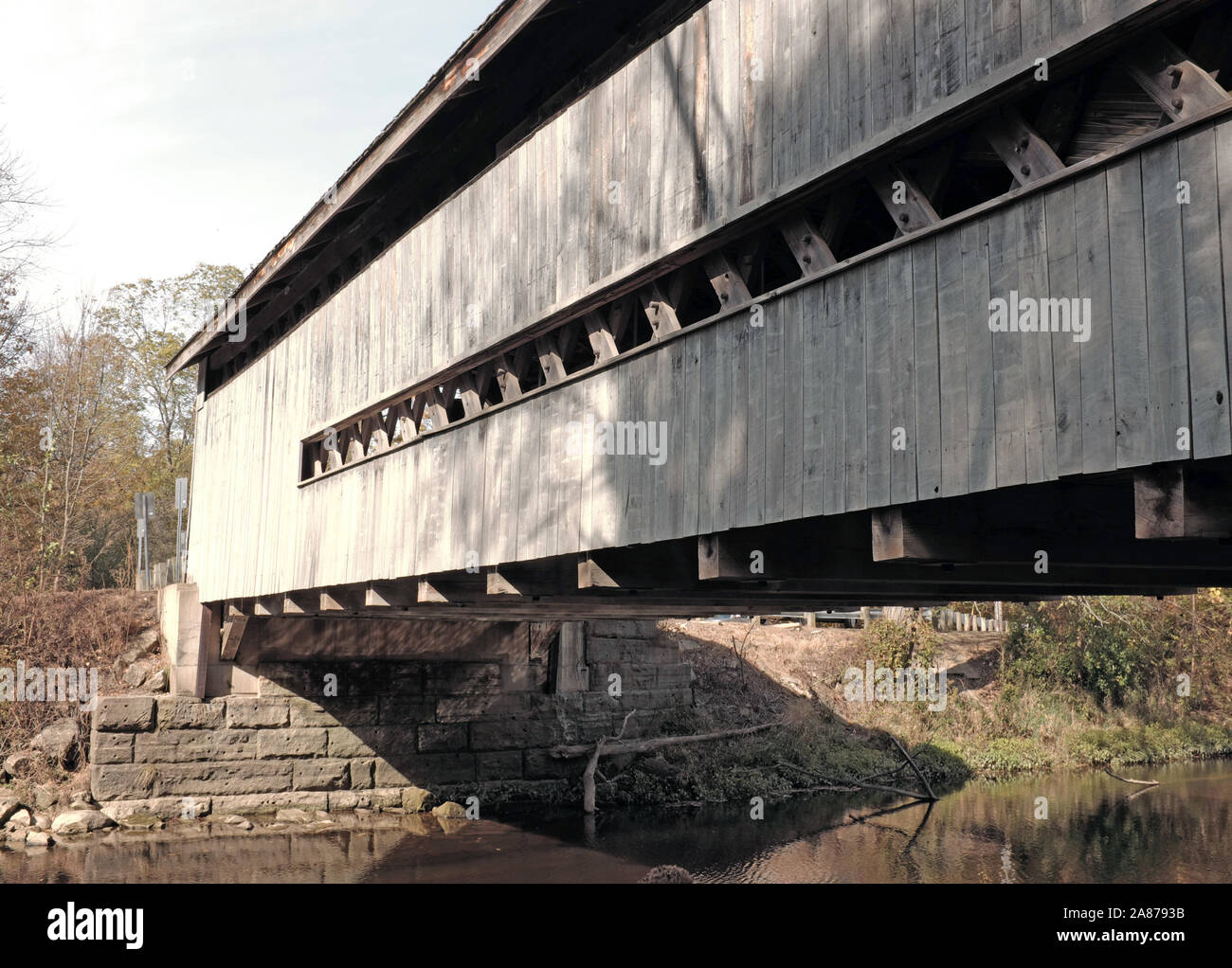 Der hölzerne abgedeckt drivable Doyle Straßenbrücke über Mill Creek in Jefferson Township, Ashtabula County, Ohio ist ein span Stadt Truss Design. Stockfoto