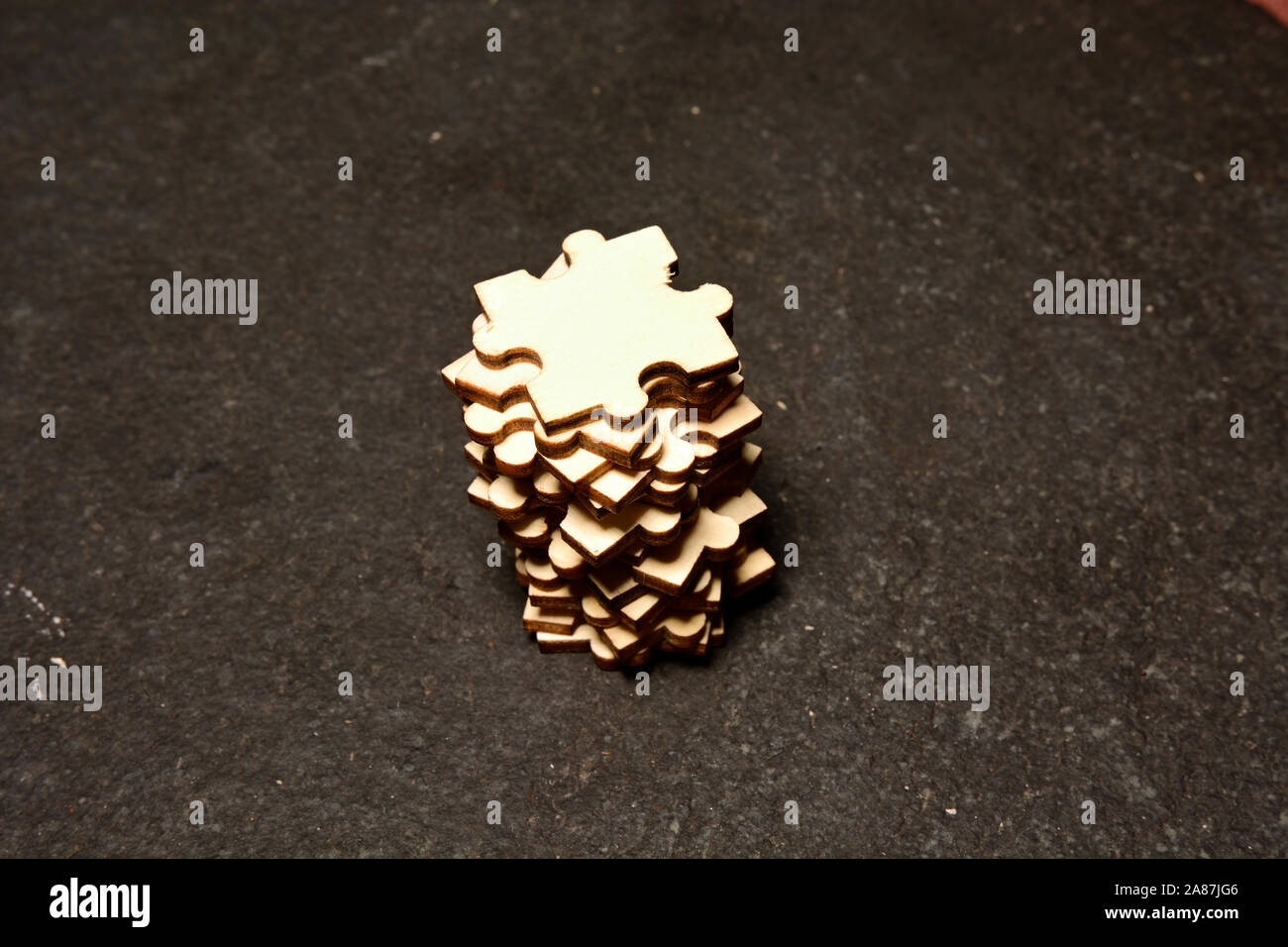 Stapel von Puzzle-Stücke auf schwarzem texturierten Hintergrund Stockfoto