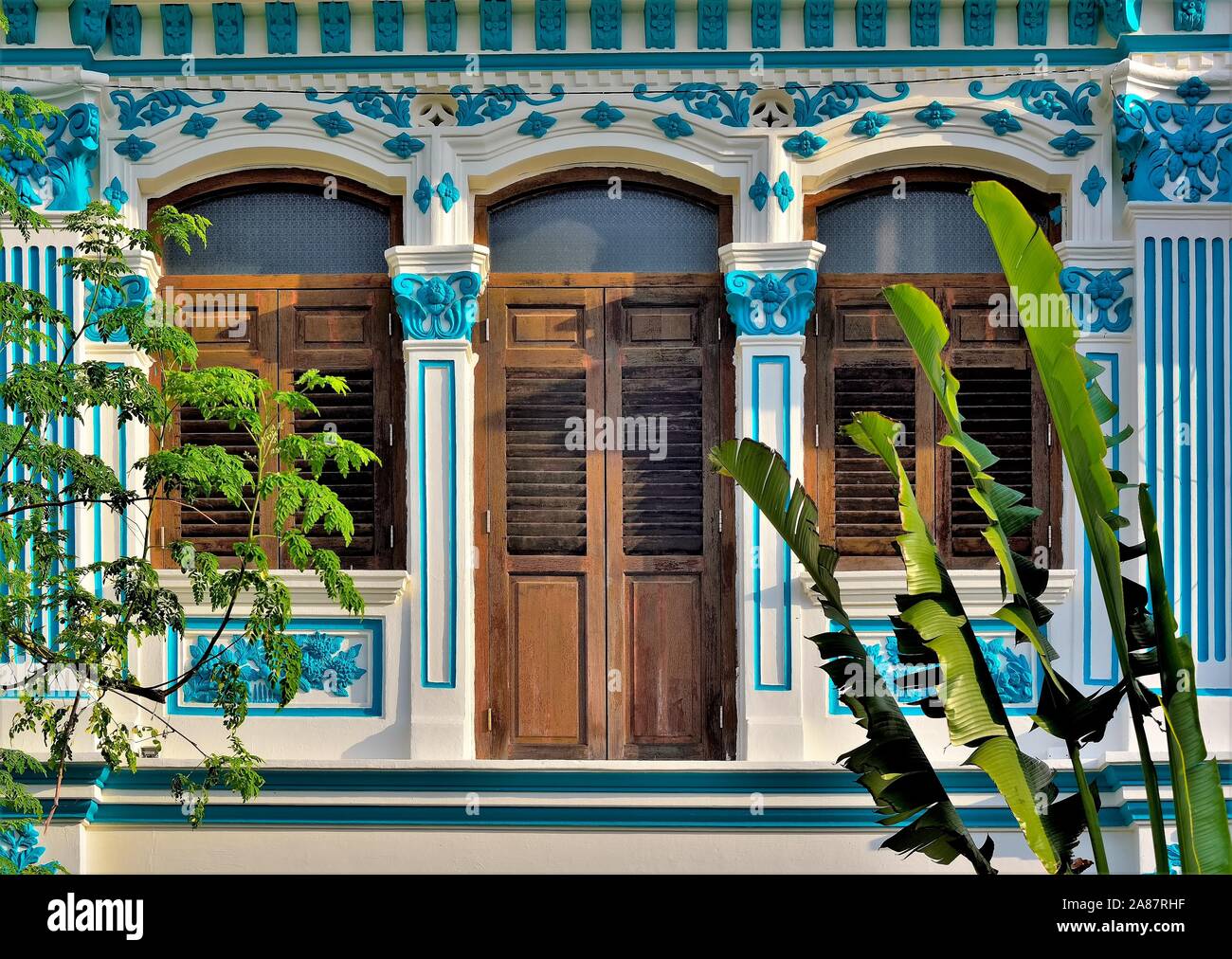 Wunderschöne traditionelle Shophouse mit Bogenfenster, antik braun Fensterläden aus Holz und blaue und weiße Fassade im historischen Joo Chiat, Singapur Stockfoto