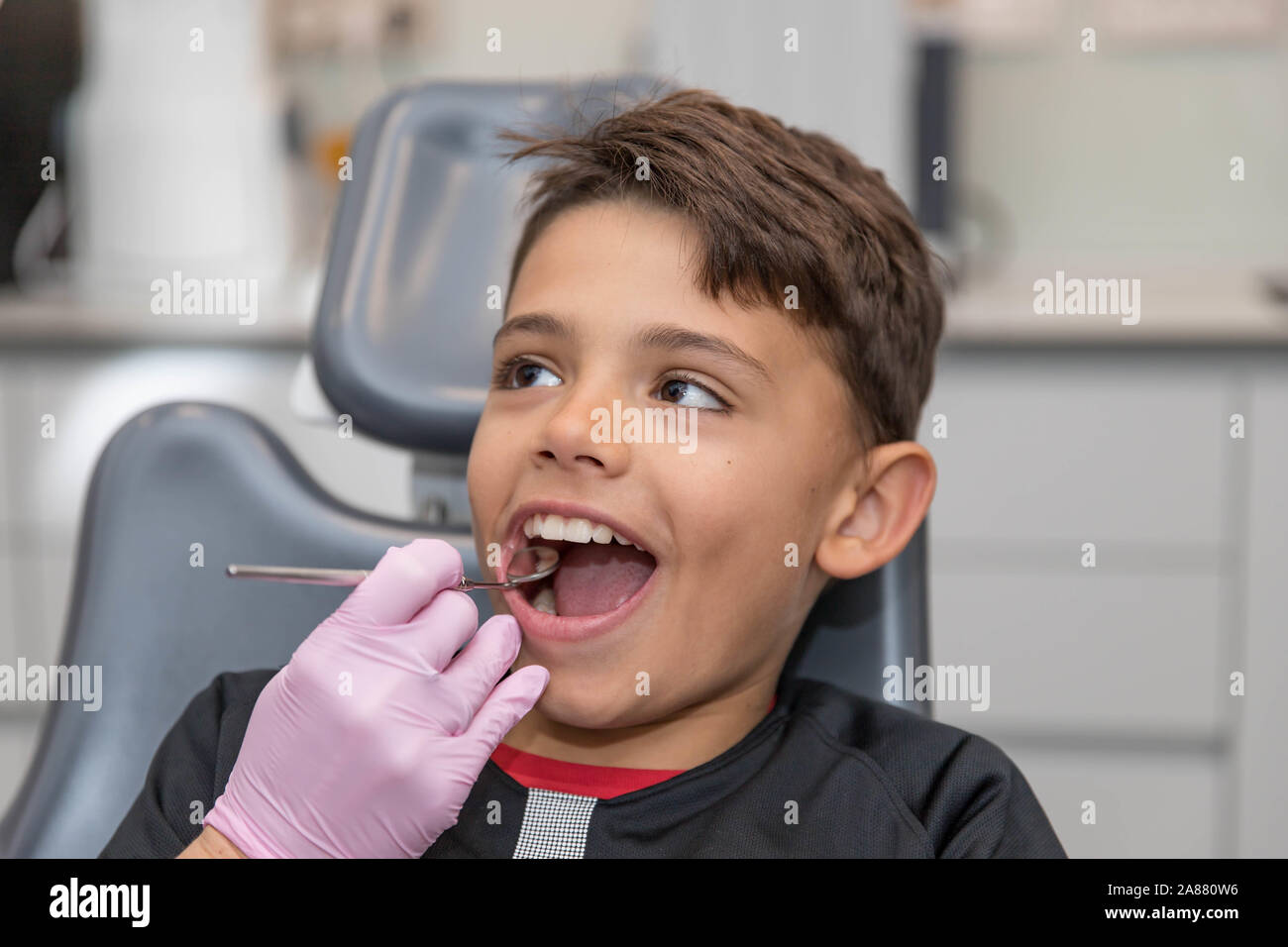 Portrait von kleinen Jungen seinen Mund weit öffnen während der Inspektion der Mundhöhle durch Zahnarzt. Stockfoto