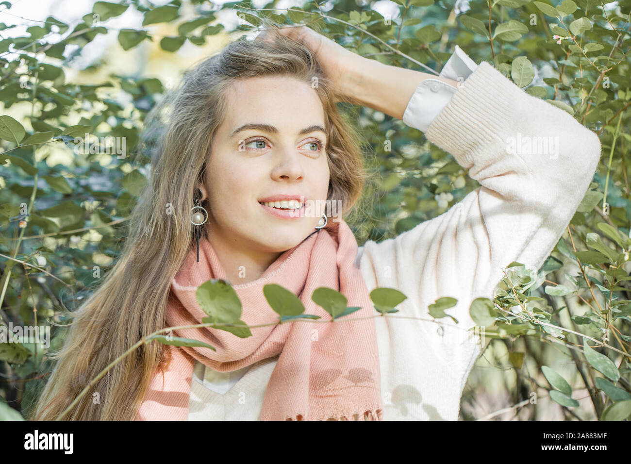 Hübsche junge echte Frau mit grünen Frühling Blätter im Park im Freien Stockfoto