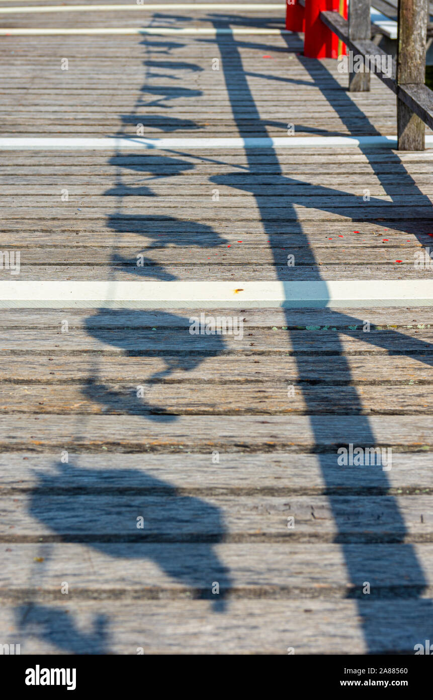 Bild von einem Holzsteg im Schatten von Laternen und Geländer - Ausgewählte konzentrieren Stockfoto