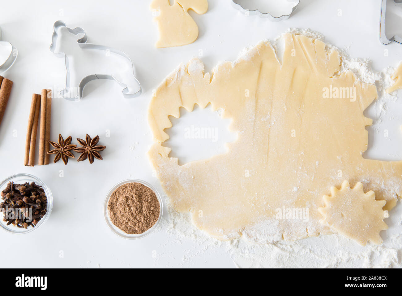 Cookies Gebäck und würzige Zutaten wie Zimtstangen, Nelken und Anis Sterne auf dem Tisch. Cookie Vorbereitung. Stockfoto