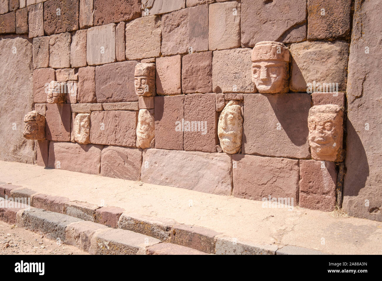 Stein zapfen Köpfe auf den Wänden der halb-unterirdischen Tempel in Tiwanaku archäologischen Komplex, Bolivien Stockfoto