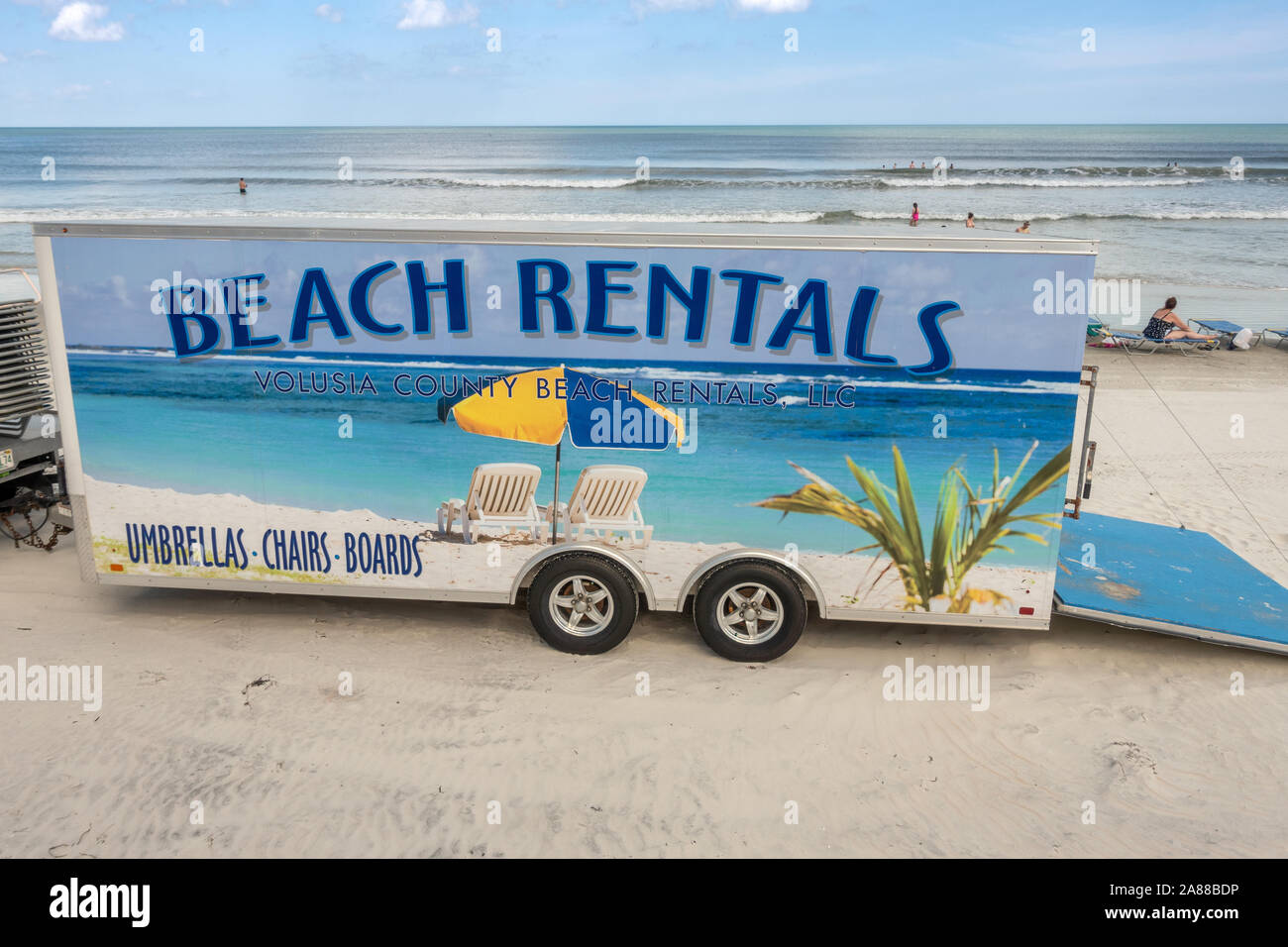 Fahrzeug Anhänger mit Strand Vermietung von Sonnenschirmen, Liegestühlen und Boards am Daytona Beach Florida. Stockfoto