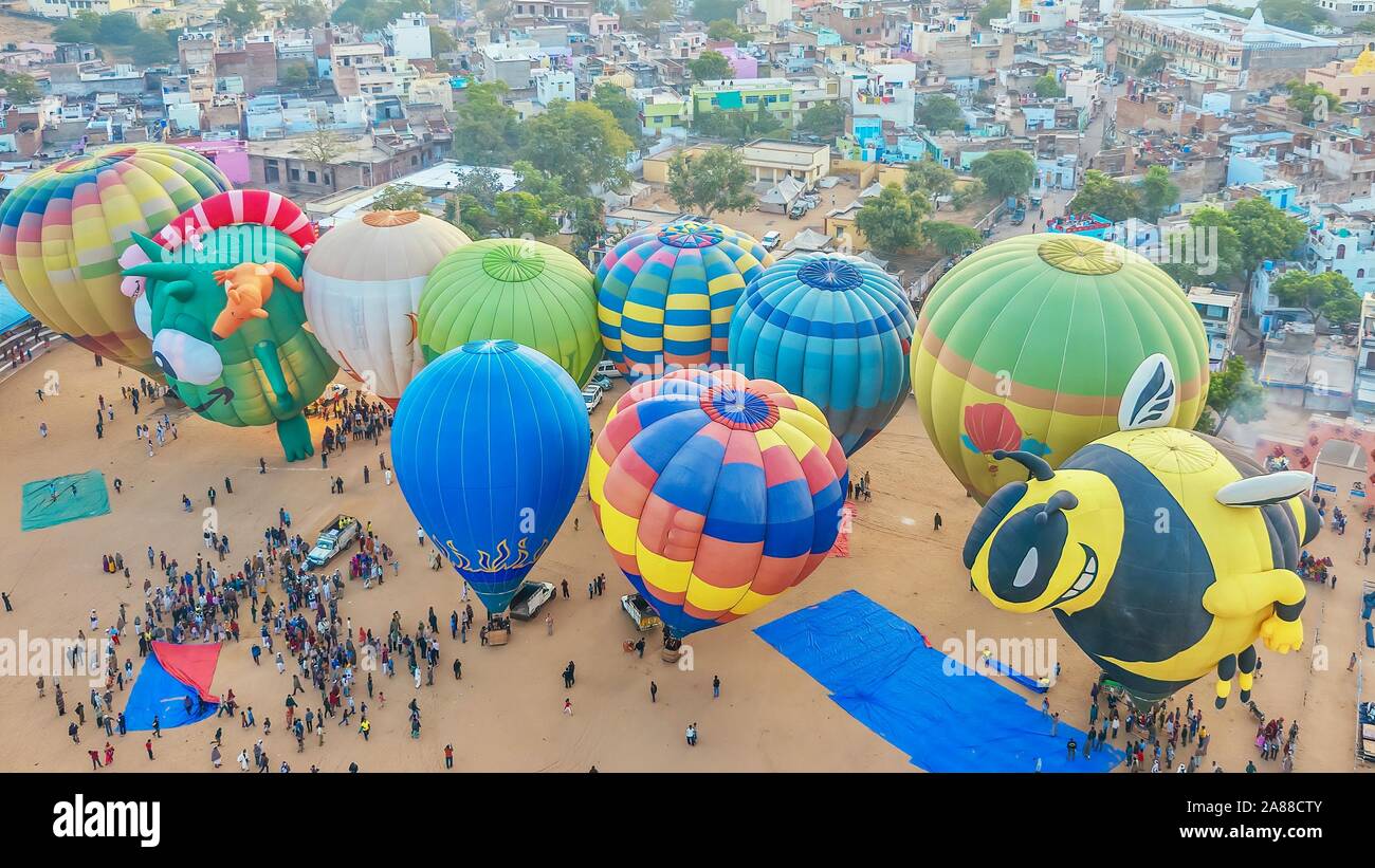 Eine bunte Szene am Pushkar Camel Fair, mit einem Luftbild von 10 Heißluftballons Vorbereitung vom Boden abheben. Stockfoto