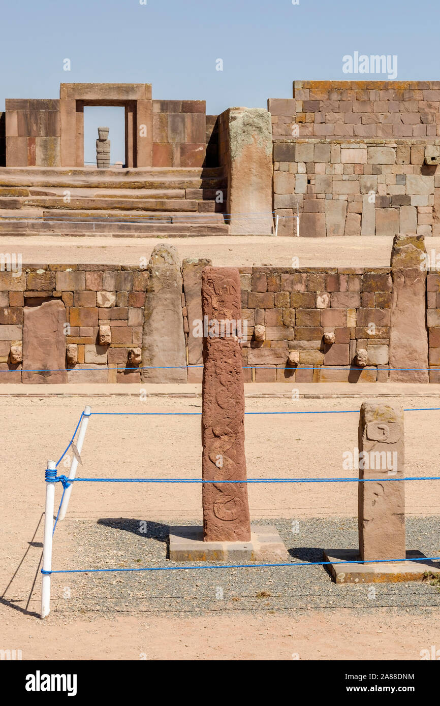 Zapfen, Köpfe auf der halb-unterirdischen Tempel mit der Kalasasaya Tempel und Ponce monolith im Hintergrund Tiwanaku archäologischen Komplex, Bolivien Stockfoto