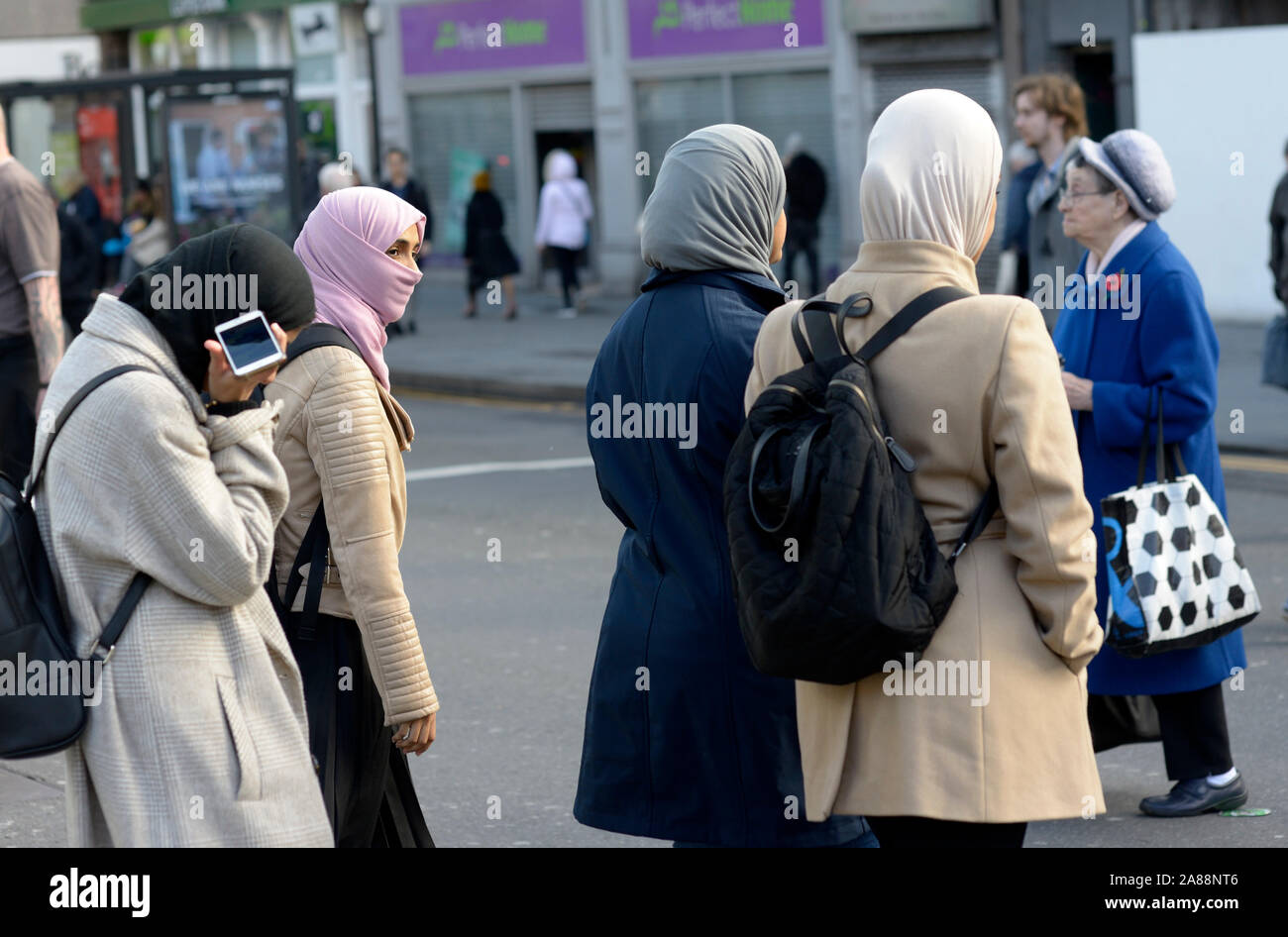 Vier muslimische Mädchen alle im Hijab. In Niqab. Überqueren Sie die Straße. Stockfoto