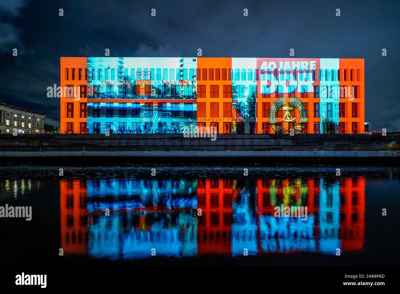 06.11.2019, das Humboldt-forum, als Teil der neu entstehenden Berliner Schloss mit einer 3D-Projektion im Rahmen des Jubiläums 30 Jahre Friedliche Revolution - Fall der Berliner Mauer. Die Projektionen werden in das Wasser der Spree spiegelte. Die grossformatige Projektion Video wurde realisiert, hier mit ein Motiv für die Feierlichkeiten "40 Jahre DDR", die von der Firma Urbanscreen aus Bremen. | Verwendung weltweit Stockfoto