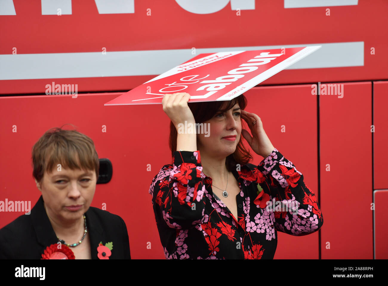 Lucy Powell Schutz vor dem Regen vor dem Arbeitskampf Bus während der allgemeinen Wahlkampagne Trail in Liverpool, neben ihr ist Maria Adler (links). Stockfoto