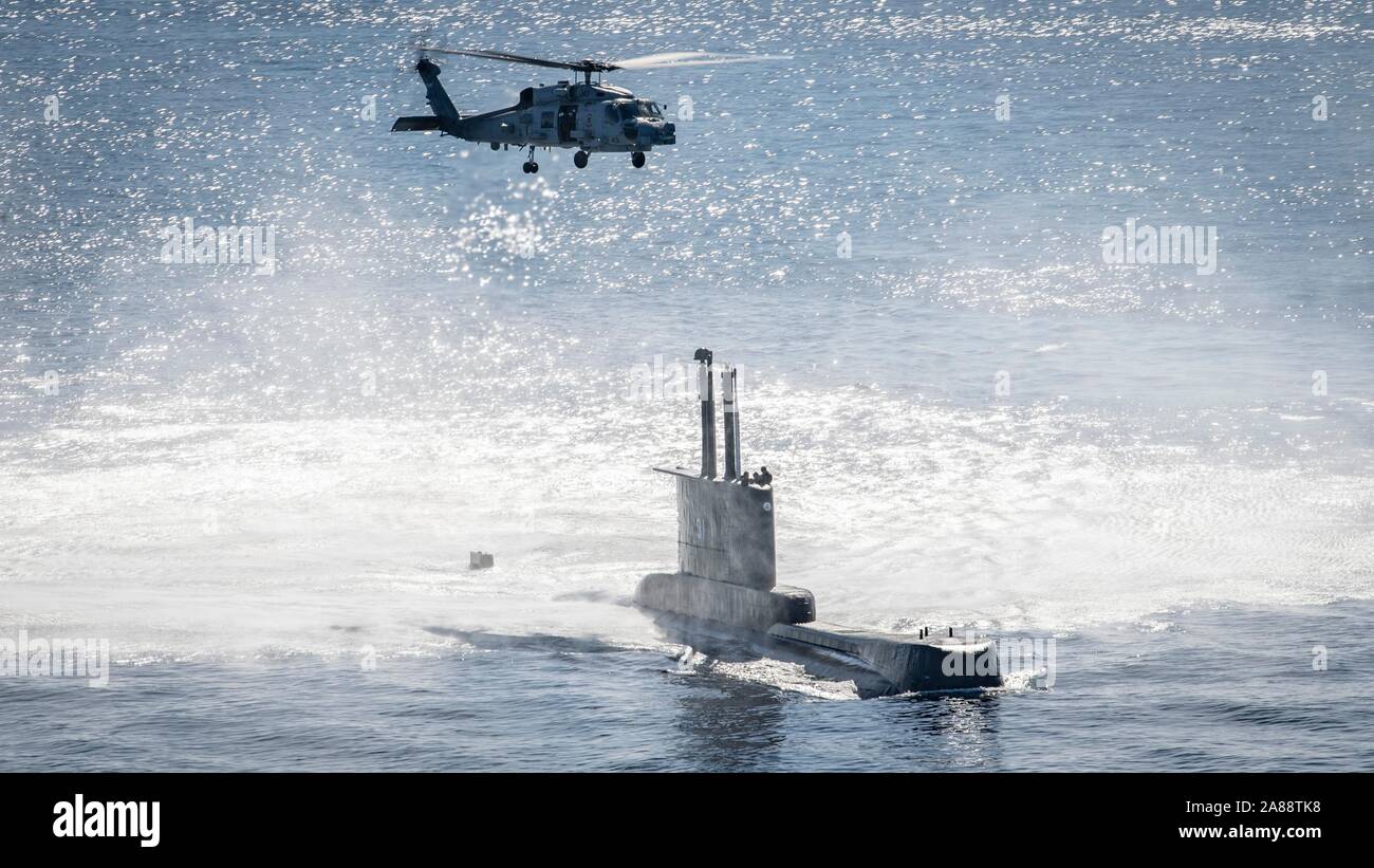 Ein U.S. Navy MH-60R Sea Hawk Hubschrauber Hubschrauber Maritime Strike Squadron 35 führt eine hoist Übung mit der Peruanische Marine u-boot BAP Angamos im Pazifischen Ozean November 1, 2019 in der Nähe der Insel San Clemente, Kalifornien. Stockfoto