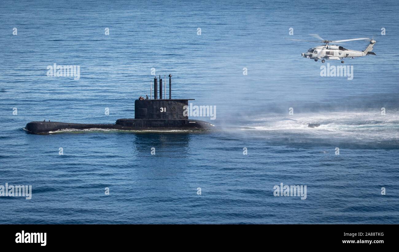 Ein U.S. Navy MH-60R Sea Hawk Hubschrauber Hubschrauber Maritime Strike Squadron 35 führt eine hoist Übung mit der Peruanische Marine u-boot BAP Angamos im Pazifischen Ozean November 1, 2019 in der Nähe der Insel San Clemente, Kalifornien. Stockfoto