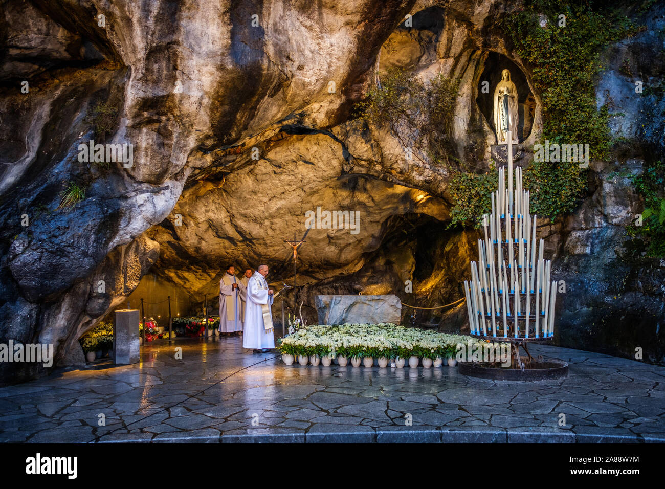 Lourdes (Frankreich). Pilger an der Grotte von Massabielle, am Ufer der Gave de Pau Fluss Stockfoto