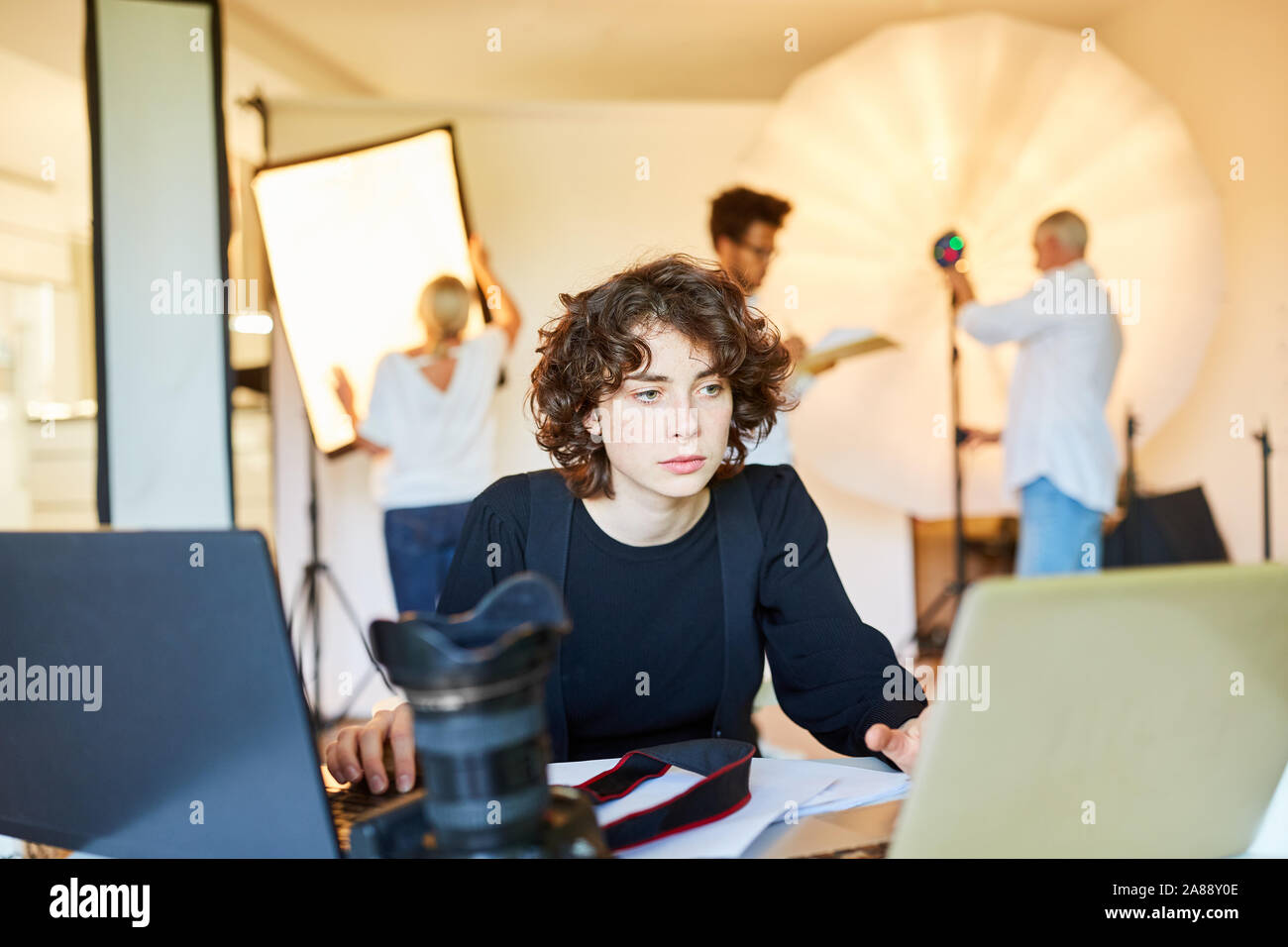Fotograf auf Laptop im Foto Studio während der Bildverarbeitung oder Datensicherung Stockfoto