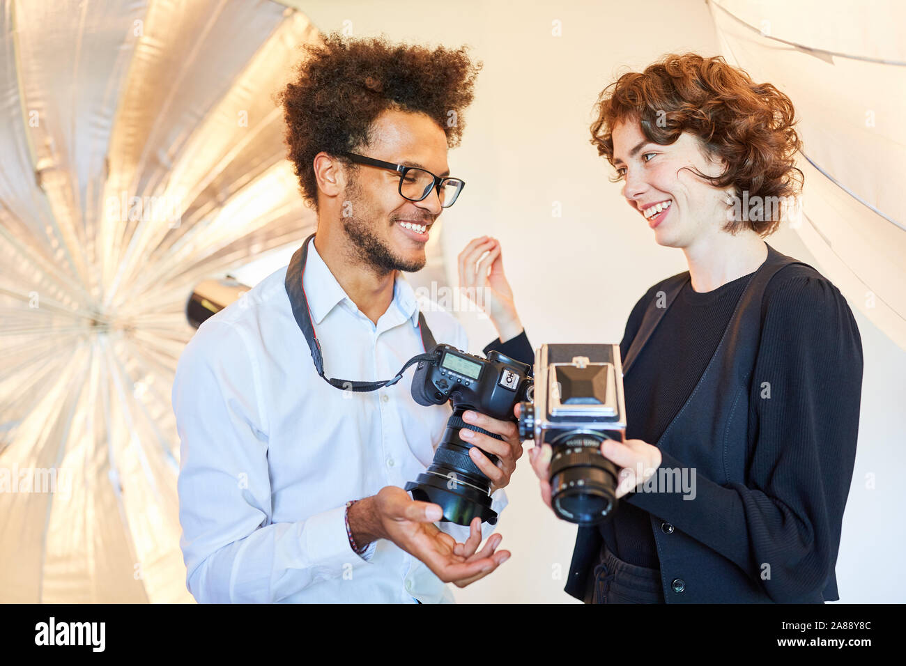 Zwei junge Studenten Foto Kamera Qualität im Vergleich zu besprechen Stockfoto