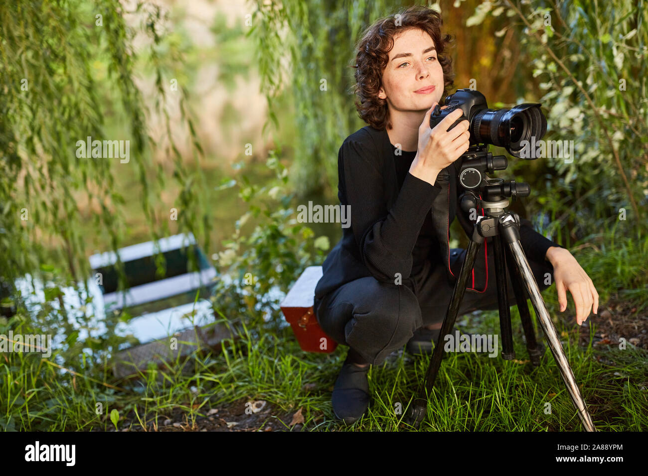 Junge Frau als Landschaft Fotograf mit Kamera und Stativ als Hobby Stockfoto