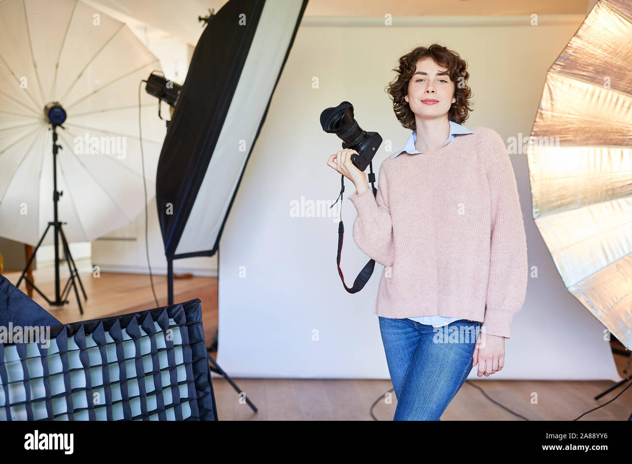 Zuversichtlich Fotograf mit der Kamera und Ausrüstung in der Photo Studio Stockfoto