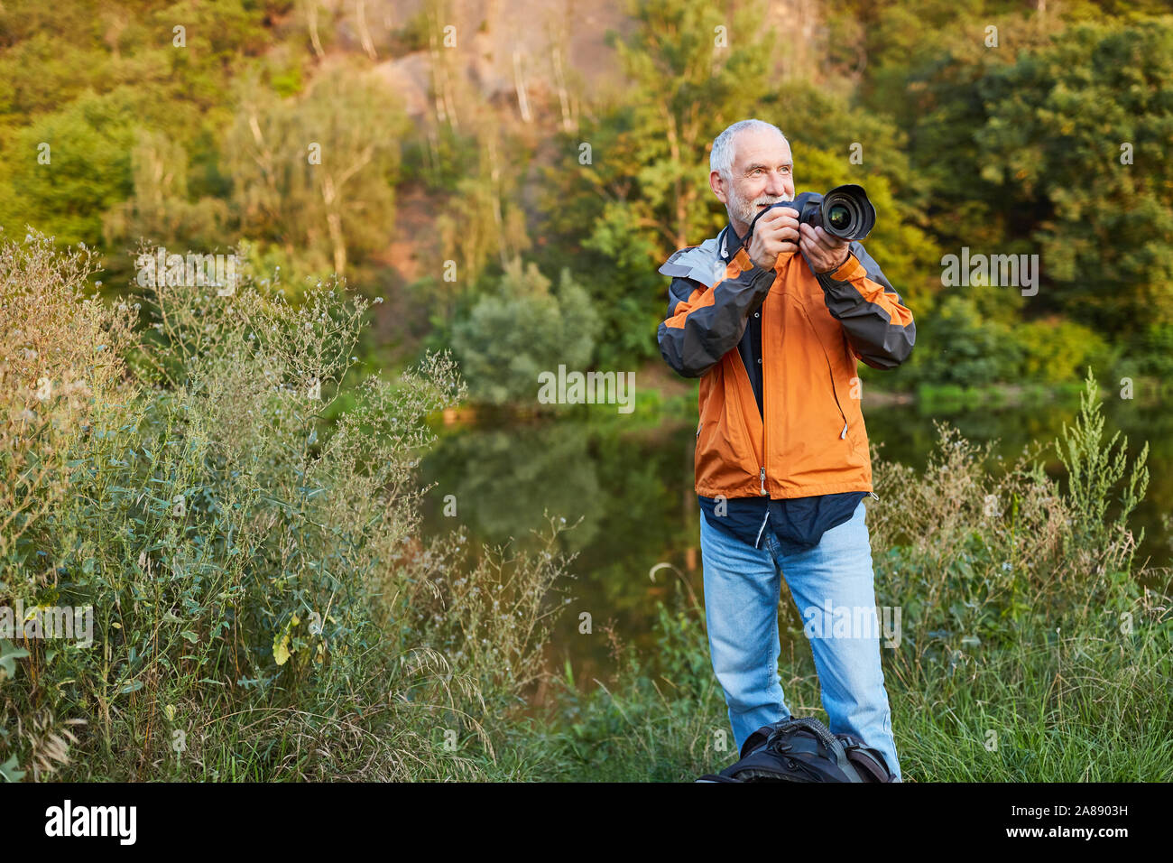 Senior Fotograf als Landschaft Fotograf beim Fotografieren in der Natur Stockfoto