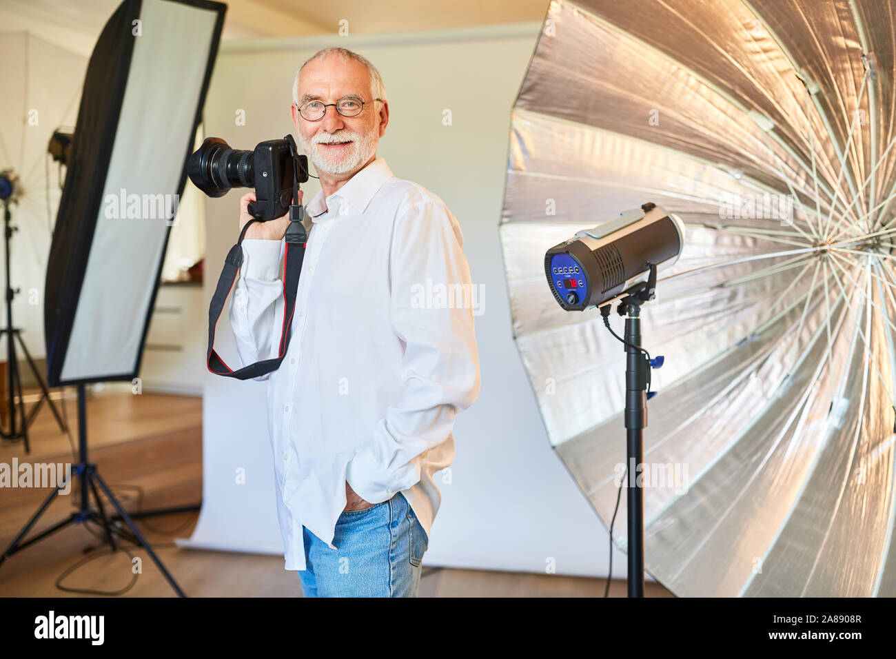 Cool freier Fotograf mit Digitalkamera vor einem Blitzgerät Stockfoto