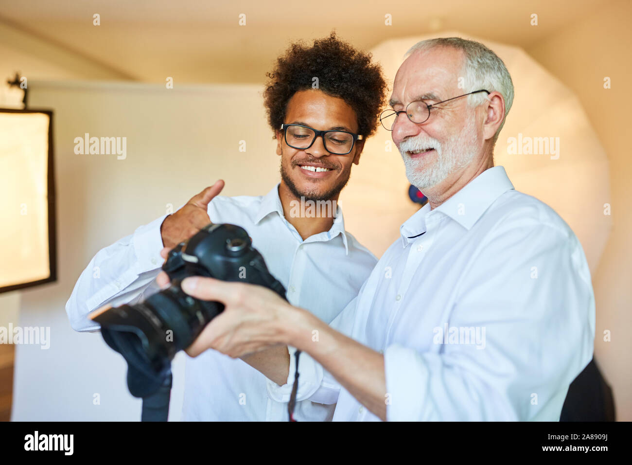 Junge foto Student und Senior Fotograf mit der Kamera in der Bildauswahl Stockfoto