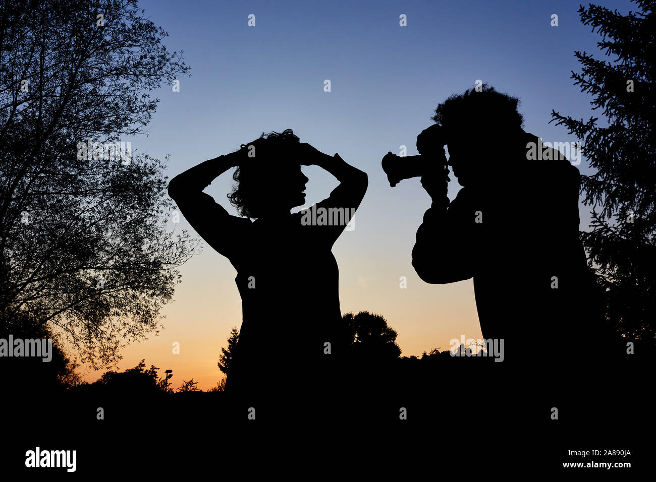 Fotograf mit Kamera nimmt Portrait Fotos der Frau in der blauen Stunde Stockfoto