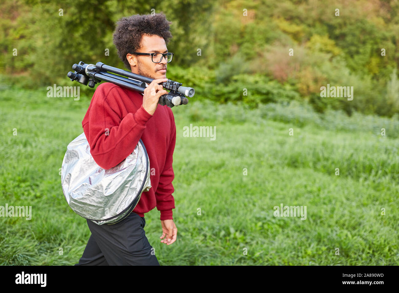 Junge Natur Fotografen mit Stativ auf die Schulter auf Motiv Suche in der Natur Stockfoto