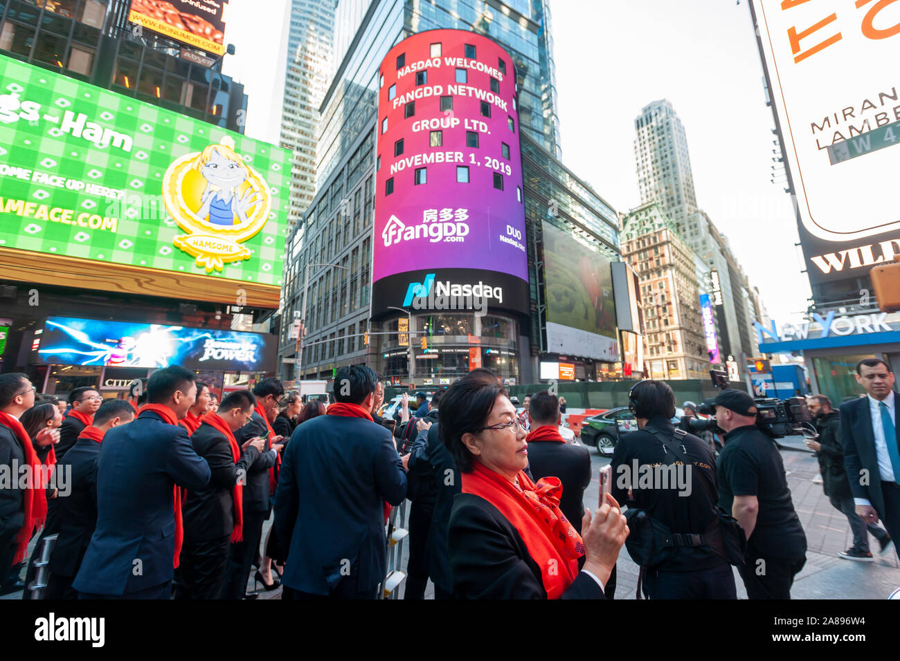 Mitarbeiter mit ihren Familien und Freunden sammeln an der riesigen Bildschirm an der Nasdaq Börse in Times Square in New York für das Debüt des FangDD Network Group (DUO) Börsengang am Freitag, den 1. November 2019 eingerichtet. FangDD Network Group ist ein on-line-Immobilien Markt in China bietet Werkzeuge auf eine mobile Plattform für Immobilienmakler. (© Richard B. Levine) Stockfoto