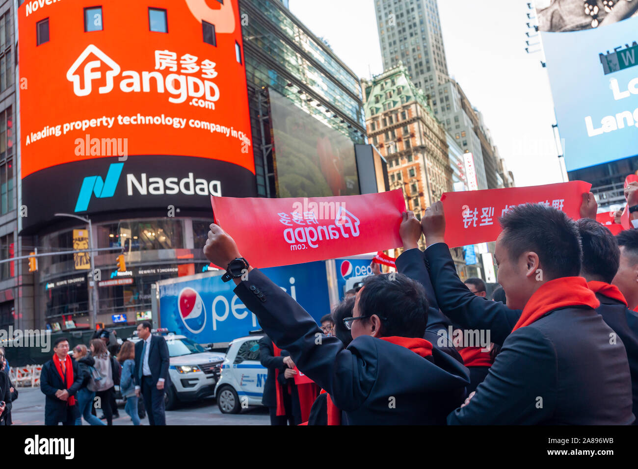 Mitarbeiter mit ihren Familien und Freunden sammeln an der riesigen Bildschirm an der Nasdaq Börse in Times Square in New York für das Debüt des FangDD Network Group (DUO) Börsengang am Freitag, den 1. November 2019 eingerichtet. FangDD Network Group ist ein on-line-Immobilien Markt in China bietet Werkzeuge auf eine mobile Plattform für Immobilienmakler. (© Richard B. Levine) Stockfoto