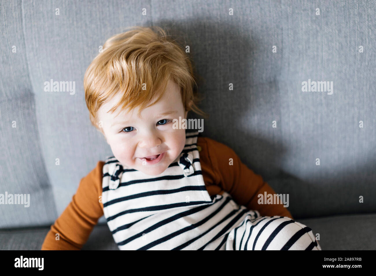 Lächelnder Junge auf dem Sofa Stockfoto Lächelnder Junge auf dem Sofa Stockfoto