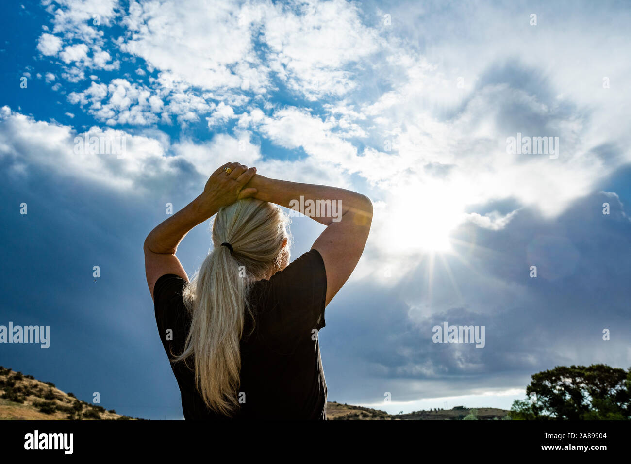 Reife Frau mit den Händen auf dem Kopf Stockfoto