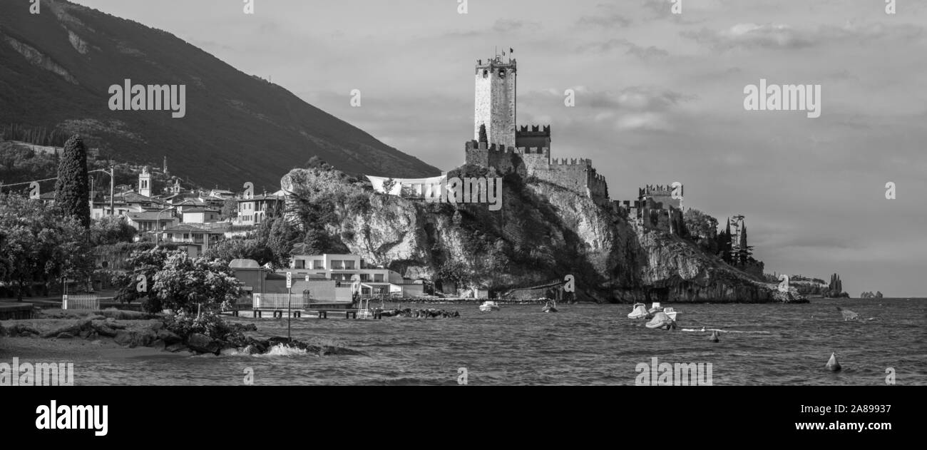 Malcesine - der Strand des Lago di Garda See, die Stadt und die Burg im Hintergrund. Stockfoto