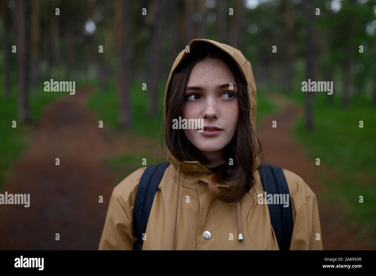 Porträt einer jungen Frau mit braunem Regenmantel Stockfoto