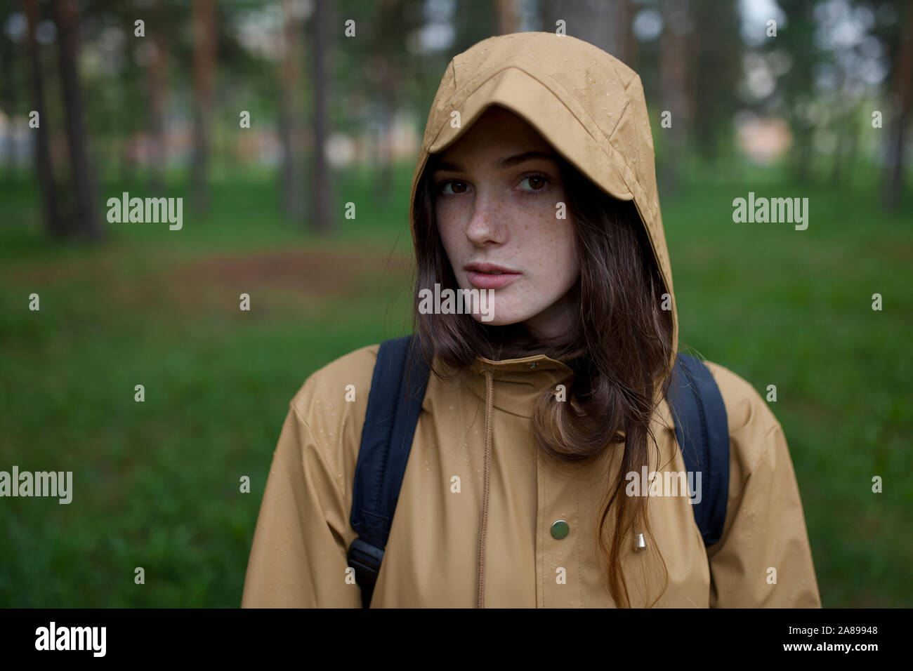 Porträt einer jungen Frau mit braunem Regenmantel Stockfoto