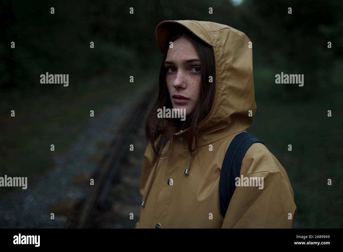 Junge Frau in braunem Regenmantel Stockfoto