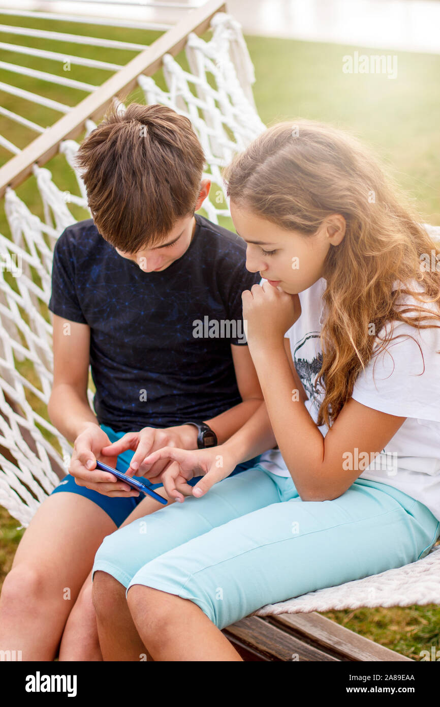 Paar junge glücklich Teens. Ein Mädchen und ein Kerl Lachen und ein Video auf einem Smartphone Stockfoto