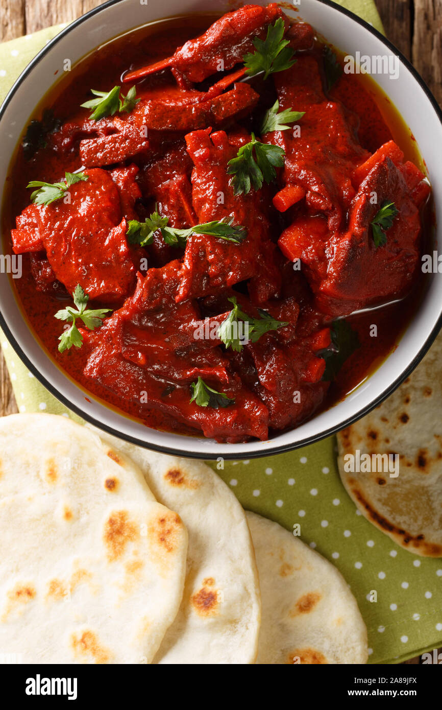 Junglee Maas ist ein reiches, dunkles Rot, würzige Ziegen fleisch Curry, der langsam gekocht zu erreichen die besten komplexe Aromen in der Platte Nahaufnahme. Vertikale Ansicht von oben Stockfoto