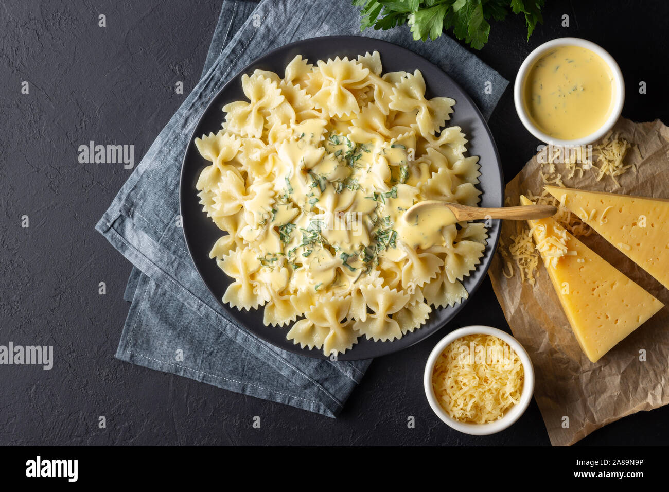 Lecker gekocht Italienische farfalle Pasta (Bow-tie oder Schmetterling) mit  Käsesoße. Ansicht von oben. Schwarzen Hintergrund Stockfotografie - Alamy